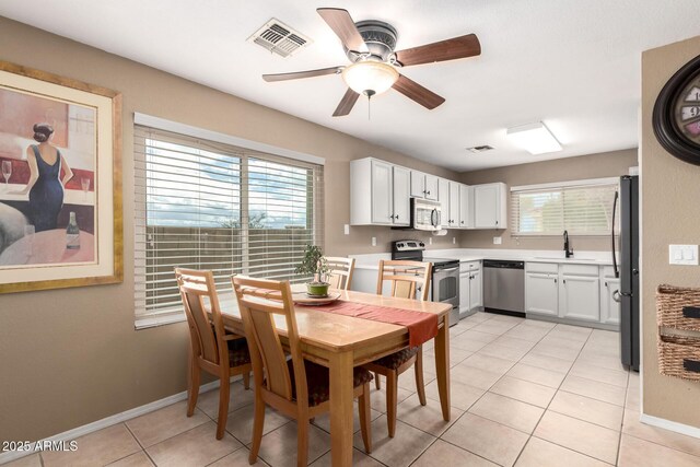 dining room featuring light tile patterned floors, a textured ceiling, visible vents, a ceiling fan, and baseboards