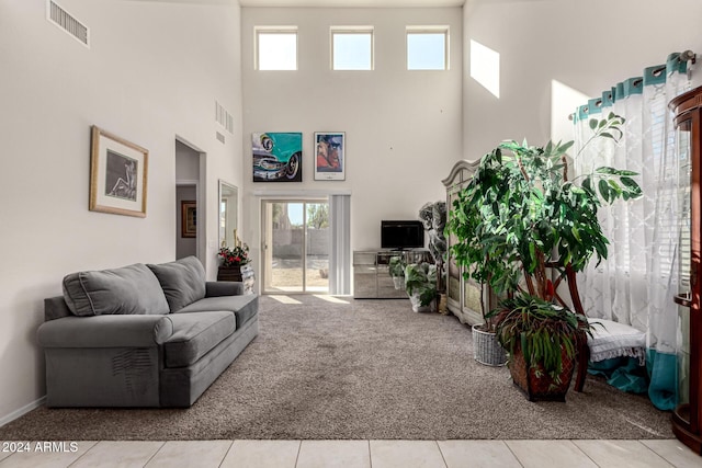 tiled living room featuring a wealth of natural light and a high ceiling