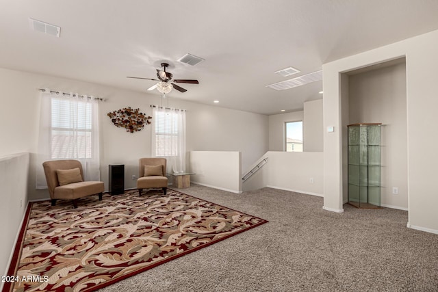 living area featuring carpet and ceiling fan