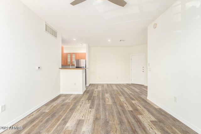 unfurnished living room with hardwood / wood-style floors and ceiling fan