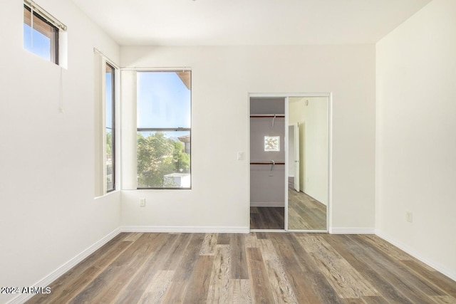 unfurnished bedroom with a closet and dark hardwood / wood-style floors