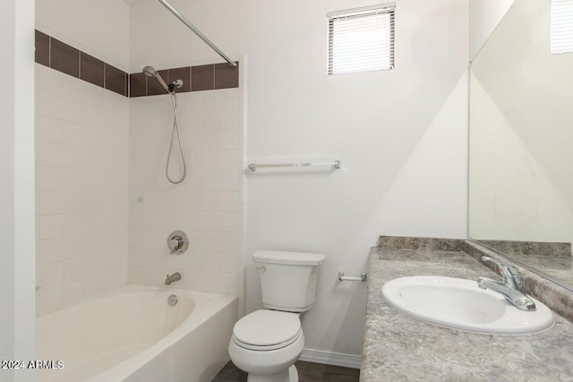 full bathroom featuring vanity, tiled shower / bath combo, toilet, and a wealth of natural light