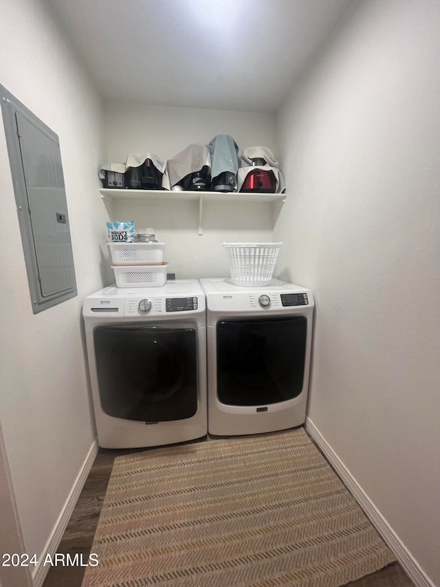 clothes washing area with electric panel, washer and clothes dryer, and dark hardwood / wood-style floors