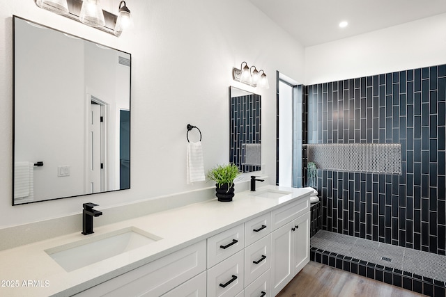 81 E Smoke Tree Rd, Gilbert, AZ 85296 - full bathroom featuring double vanity, a tile shower, recessed lighting, and wood finished floors