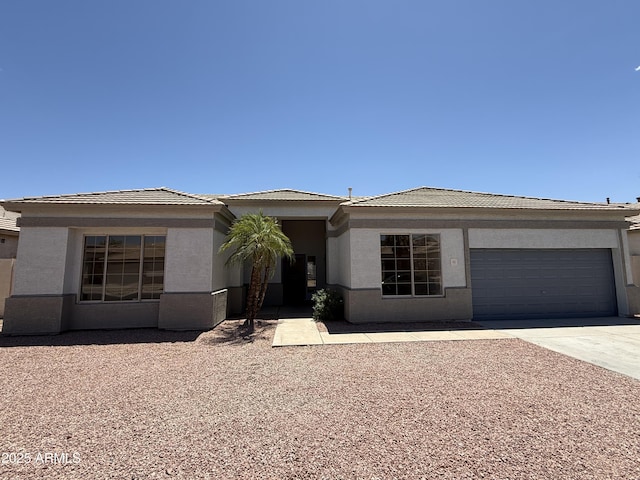 81 E Smoke Tree Rd, Gilbert, AZ 85296 - view of front of house featuring a garage, driveway, stucco siding, and a tiled roof