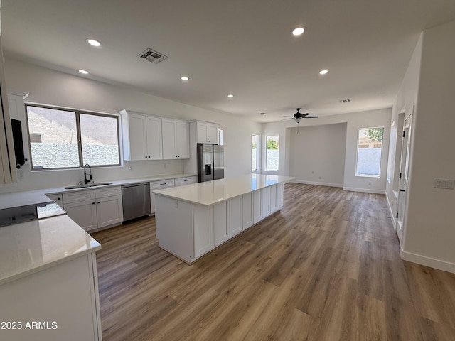 81 E Smoke Tree Rd, Gilbert, AZ 85296 - kitchen with stainless steel appliances, a kitchen island, recessed lighting, light wood-style flooring, and a ceiling fan