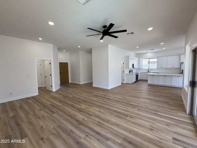 81 E Smoke Tree Rd, Gilbert, AZ 85296 - unfurnished living room with a ceiling fan, recessed lighting, and light wood-type flooring