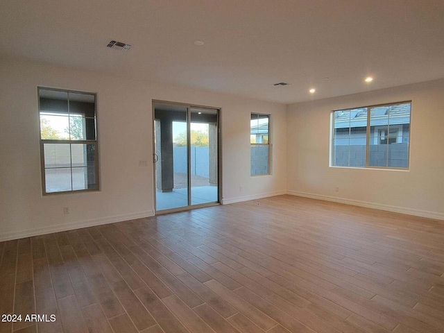 unfurnished room featuring hardwood / wood-style flooring and a healthy amount of sunlight