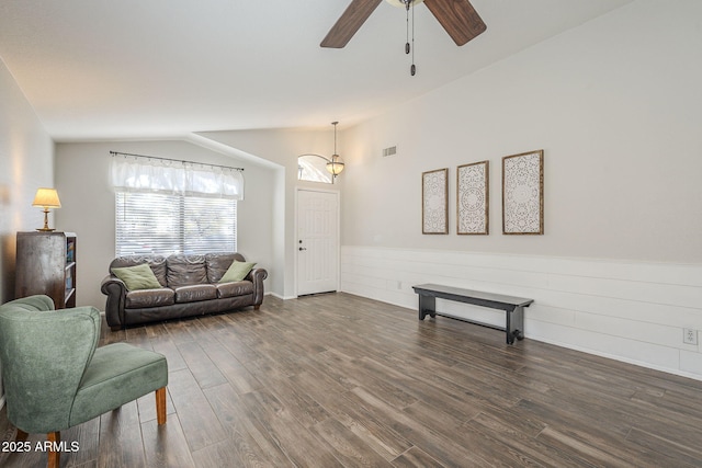 living room featuring dark hardwood / wood-style floors, ceiling fan, and vaulted ceiling