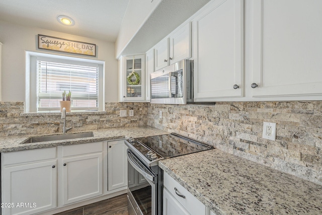 kitchen featuring decorative backsplash, sink, white cabinetry, and stainless steel appliances