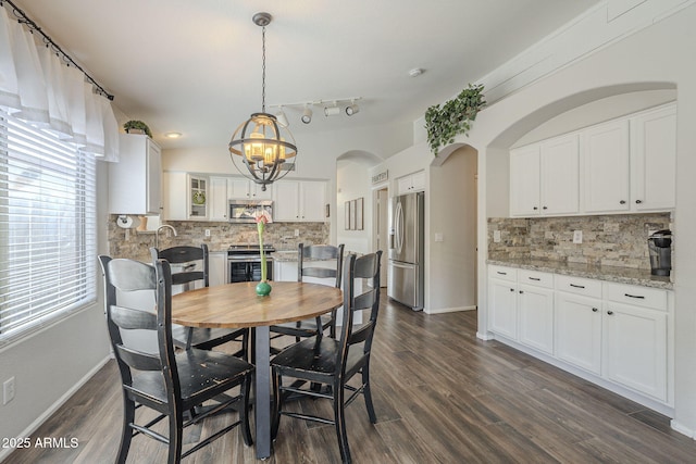 dining space with a notable chandelier and dark hardwood / wood-style floors