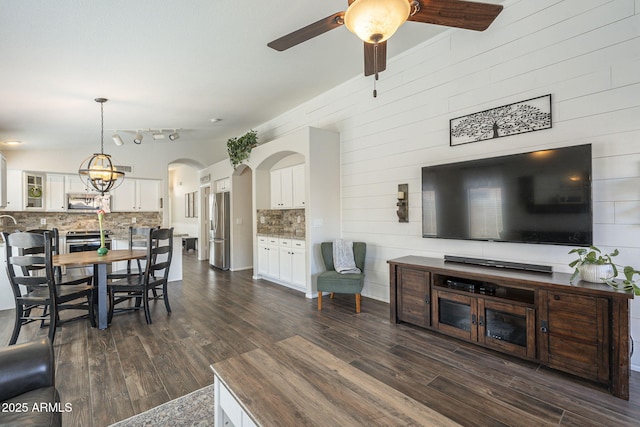 living room featuring ceiling fan and dark wood-type flooring