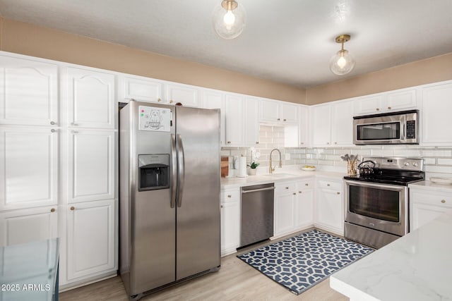 kitchen featuring a sink, appliances with stainless steel finishes, and white cabinetry