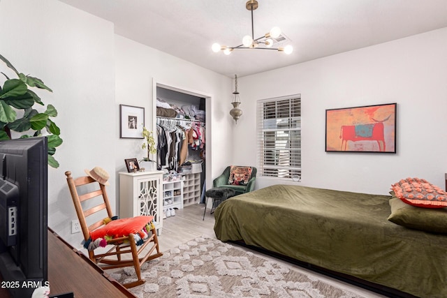 bedroom with a chandelier and wood finished floors