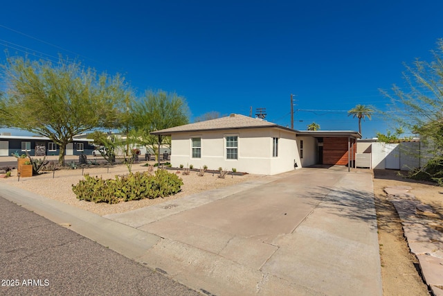 single story home featuring stucco siding, a carport, and concrete driveway