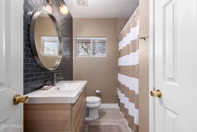 full bath with visible vents, toilet, backsplash, wood finished floors, and vanity