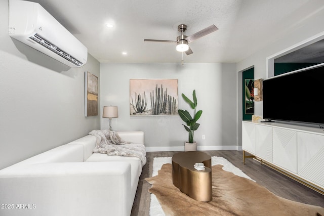 living room with a wall mounted AC, wood finished floors, recessed lighting, baseboards, and ceiling fan