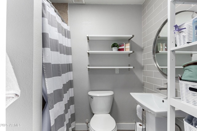 full bath with a shower with curtain, toilet, visible vents, and baseboards