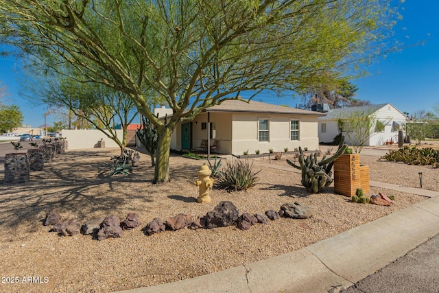 ranch-style home with stucco siding and fence