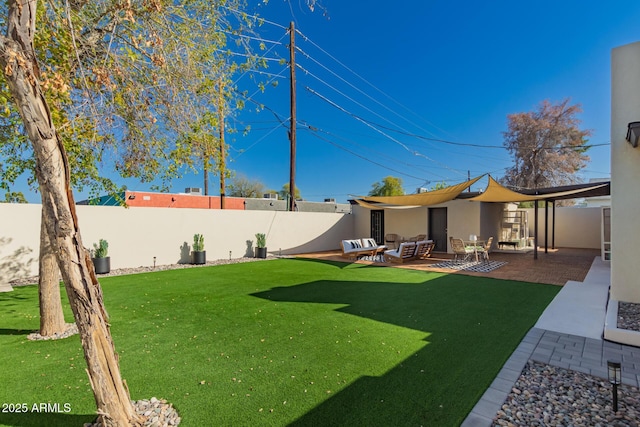 view of yard with an outdoor living space, a fenced backyard, and a patio area