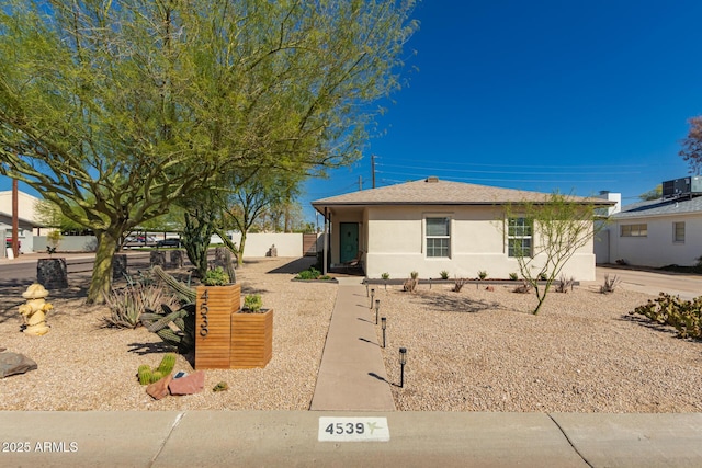 view of front of house featuring stucco siding and fence