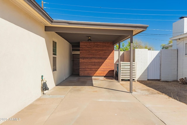 view of patio featuring a carport and fence