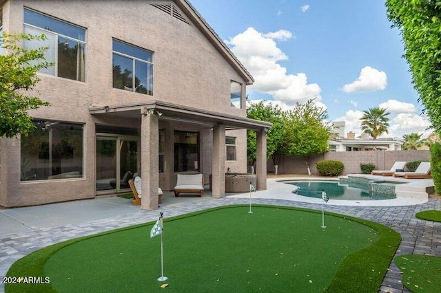 6449 E Paradise Ln, Scottsdale, AZ 85254 - back of house with a putting green, a patio area, an in-ground hot tub, and stucco siding