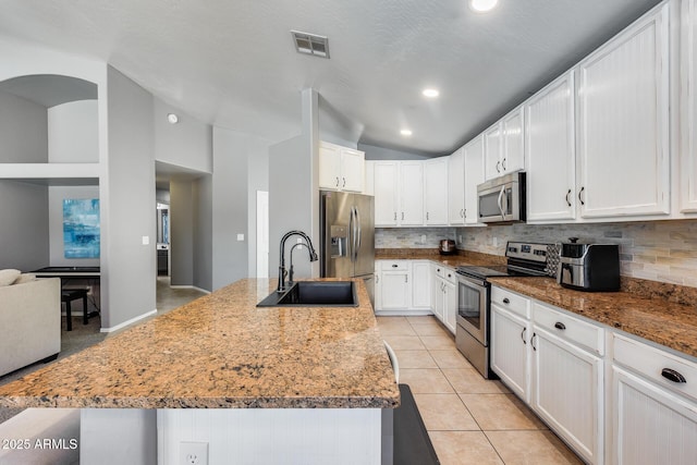 7435 W Trails Dr, Glendale, AZ 85308 - kitchen with appliances with stainless steel finishes, lofted ceiling, decorative backsplash, white cabinets, and light tile patterned floors