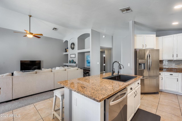 7435 W Trails Dr, Glendale, AZ 85308 - kitchen with stainless steel appliances, light tile patterned floors, a ceiling fan, an island with sink, and light stone countertops