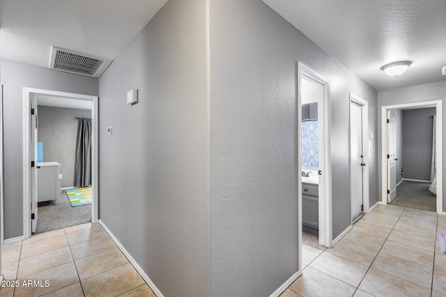 7435 W Trails Dr, Glendale, AZ 85308 - hallway featuring light tile patterned floors and a textured wall