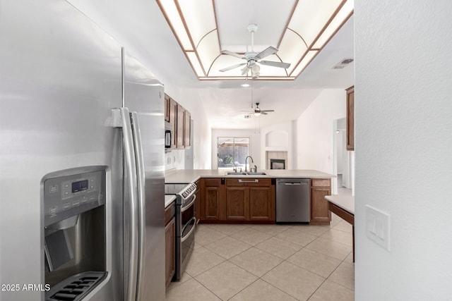 kitchen with sink, light tile patterned floors, ceiling fan, appliances with stainless steel finishes, and kitchen peninsula