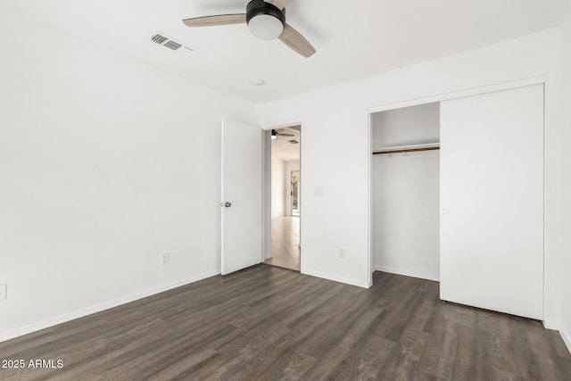 unfurnished bedroom featuring ceiling fan, dark hardwood / wood-style flooring, and a closet