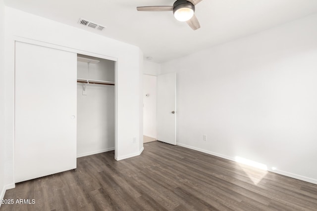 unfurnished bedroom featuring ceiling fan, dark hardwood / wood-style flooring, and a closet