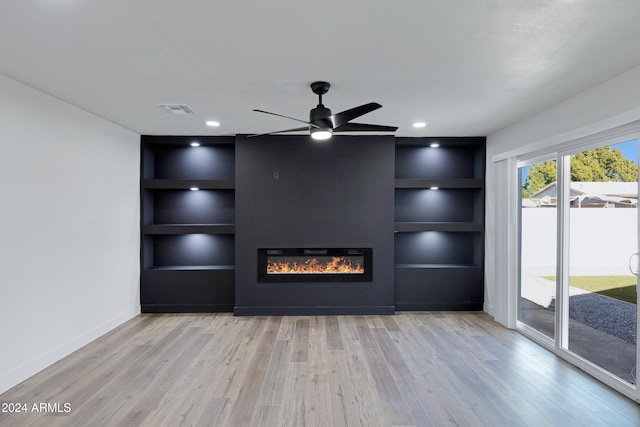 unfurnished living room with ceiling fan, light wood-type flooring, and built in features