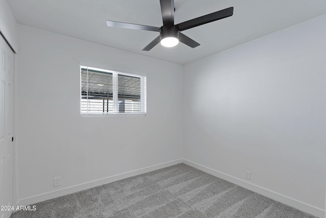 carpeted spare room featuring ceiling fan