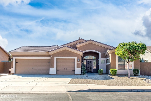 ranch-style house featuring driveway, an attached garage, a tile roof, and stucco siding