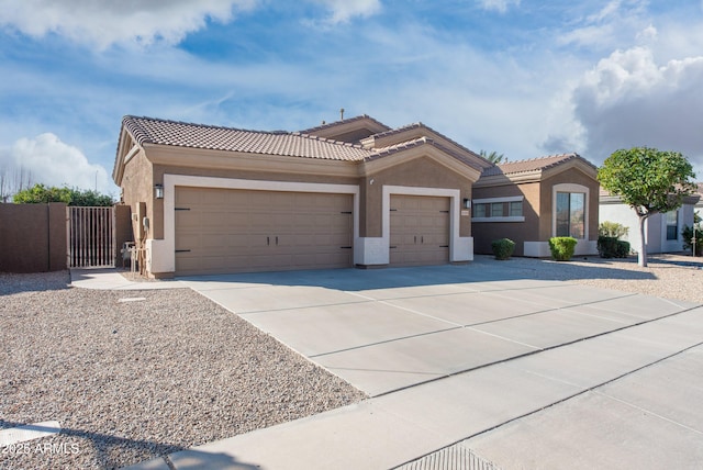 view of front of home featuring concrete driveway, a tile roof, an attached garage, and stucco siding