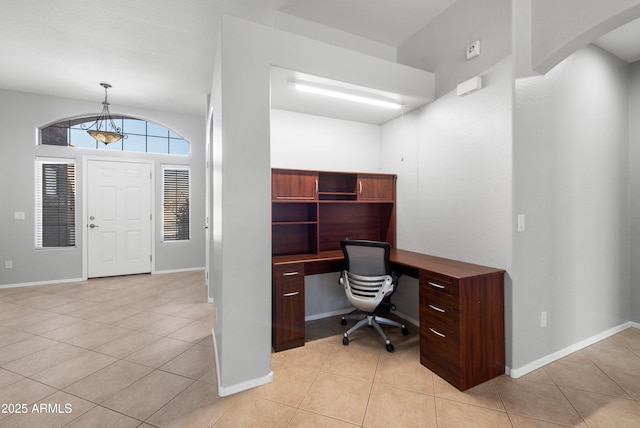 office featuring baseboards, arched walkways, and light tile patterned flooring