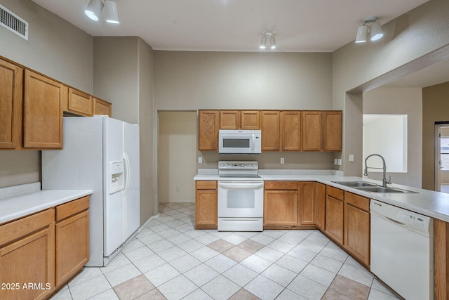 8660 E Nido Ave, Mesa, AZ 85209 - kitchen with white appliances, light countertops, light tile patterned floors, and brown cabinetry
