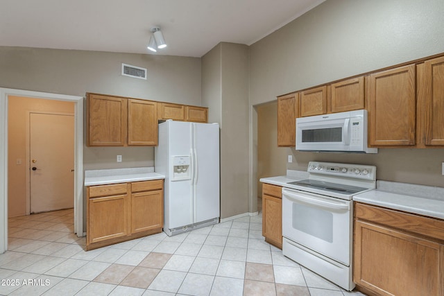 8660 E Nido Ave, Mesa, AZ 85209 - kitchen with white appliances, light countertops, brown cabinetry, and light tile patterned floors