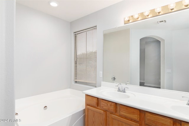 bathroom with vanity and a tub