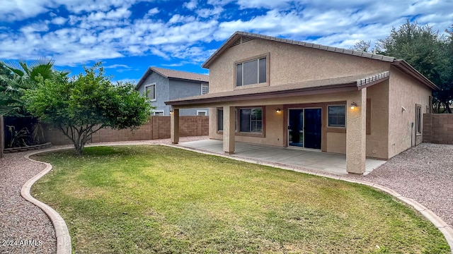 back of house with a patio area and a yard