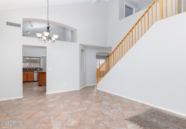 interior space featuring high vaulted ceiling and a notable chandelier