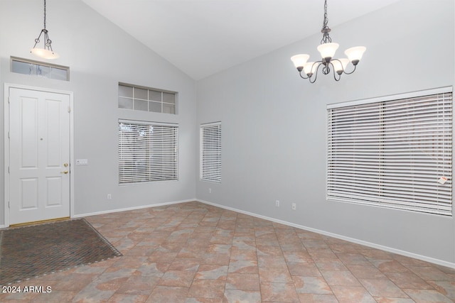 foyer entrance featuring high vaulted ceiling and a chandelier