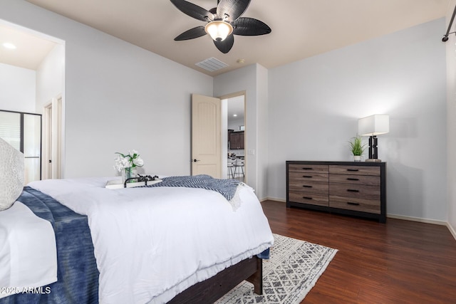 bedroom with dark wood-type flooring, baseboards, visible vents, and ceiling fan