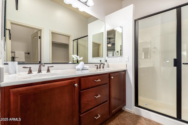 full bathroom with tile patterned flooring, double vanity, a stall shower, and a sink