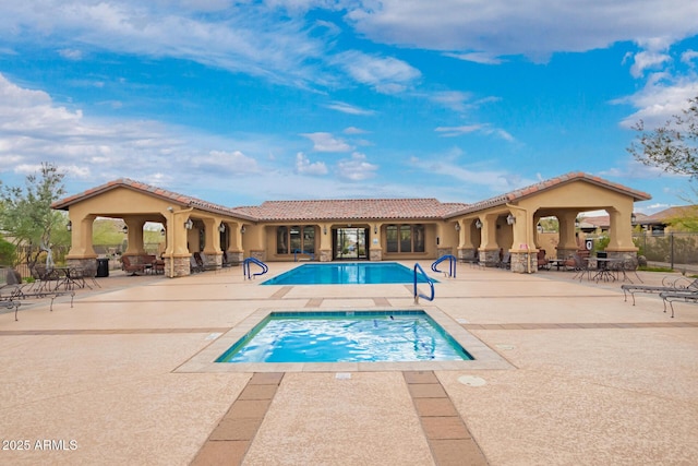 view of pool featuring a fenced in pool, a patio, and an in ground hot tub