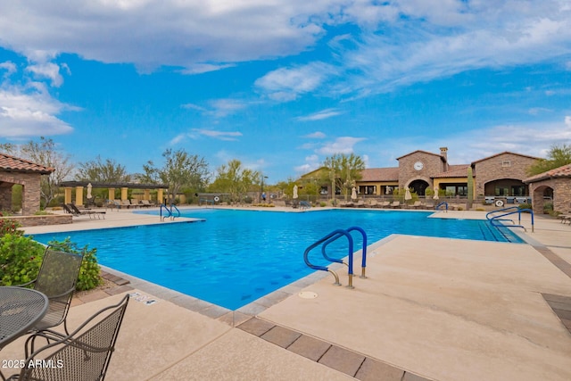 pool with a patio, an outdoor fireplace, and a pergola