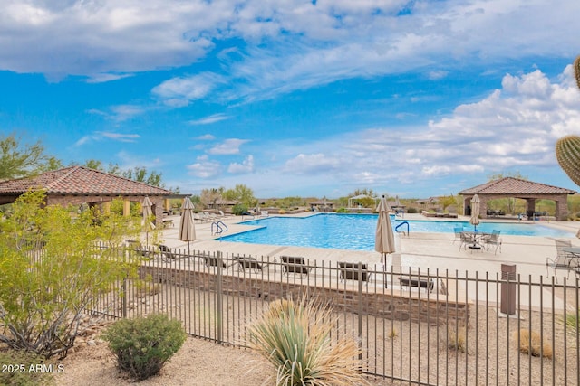 community pool with a gazebo, a patio area, and fence