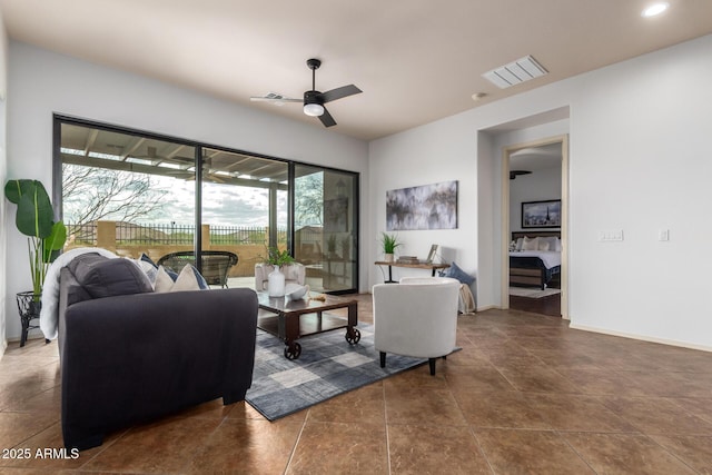 living area featuring tile patterned floors, visible vents, baseboards, and a ceiling fan